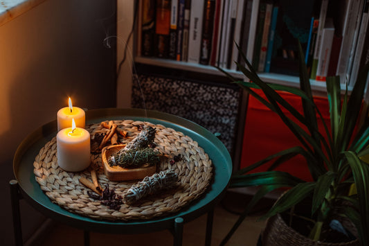 Ljus, rökelse och naturliga ritualföremål i ett varmt hem