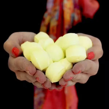 Händer som håller flera gula Chill Pill-mini-badbomber – priset avser 1
