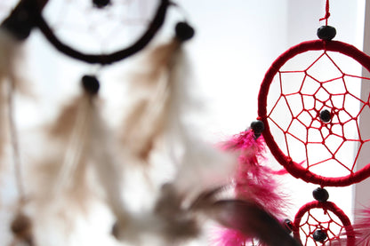 Närbild av röd drömfångare med mindre ring och rosa fjädrar