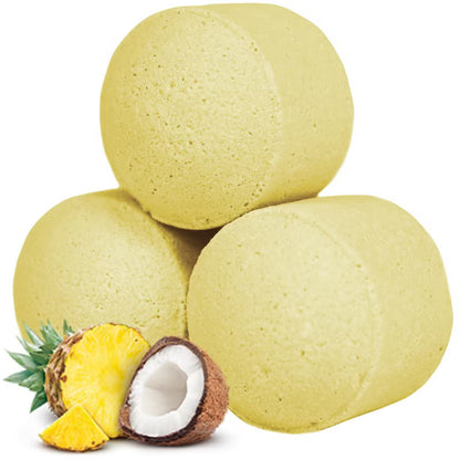 Tre gula badbomber med ananas och kokosnöt som dekoration