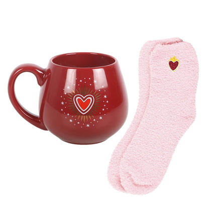 Röd Sacred Heart-mugg bredvid rosa strumpor