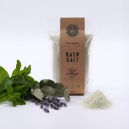 Påse Green Man-badsalt med blad och lila blommor som rekvisita